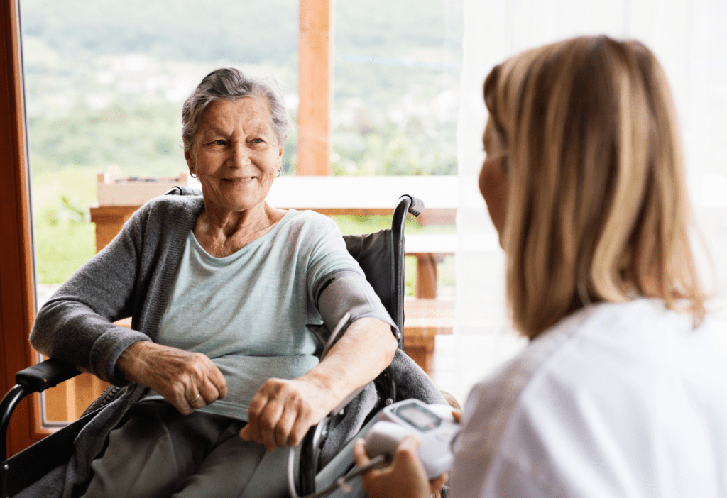 personne âgée dans un fauteuil roulant en consultation avec un professionnel de santé